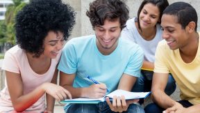 Eine Gruppe multiethnischer Studierender lernt im Sommer auf dem Campus im Freien.